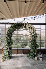 Flower Arch Natural Decoration of Wedding Day Photo. Floral Construction Built from Aroma Floral Buds and Tree Green Leaves for Celebrating Marriage Festival Event on Restaurant Terrace
