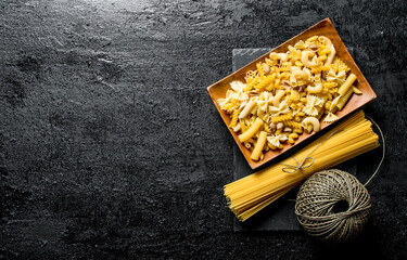 An assortment of different types of pasta dry on a plate with twine.