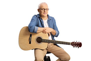 Portrait of a mature man with an acoustic guitar sitting on a chair