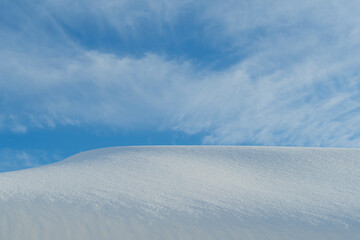 Blue sky with clouds and horizon from a snowdrift