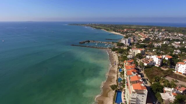 Aerial view of drone flying above Punta Mita with beautiful beach views of ocean waves and water crashing on to sandy beach from high angle. 
