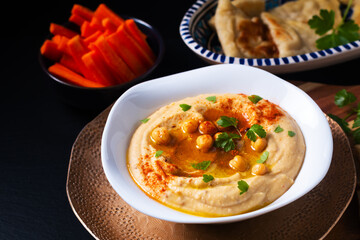 Healthy Food concept homemade hummus with flatbread pita and carrots on black background with copy space