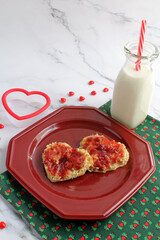 Heart-shaped toasted English muffins with strawberry jam. A treat for the kiddos on Valentine's Day.