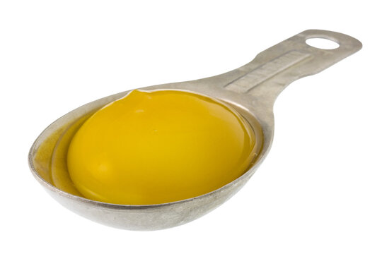 egg yolk on measuring tablespoon on a transparent background