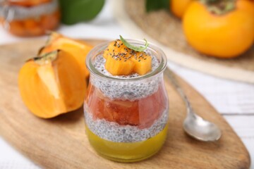 Fototapeta na wymiar Delicious dessert with persimmon and chia seeds on table