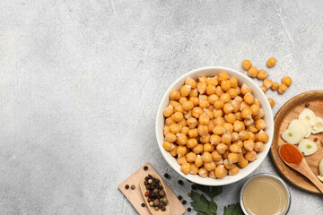 Delicious chickpeas and different ingredients on light grey table, flat lay with space for text. Cooking hummus