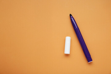 Purple marker on light brown background, flat lay. Space for text