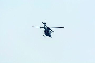 Combat helicopter is flying against isolated blue sky. Combat helicopter attack enemy