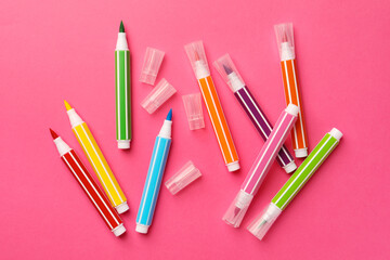 Many bright markers on pink background, flat lay
