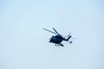 Combat helicopter is flying against isolated blue sky. combat helicopter attack enemy.