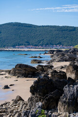 Sea view with beach and a colorful sky above the blue sea. The beach coast is shown with the beach sand. The clouds have different levels and layers and colors