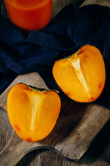 A group of ripe orange persimmon fruits.Persimmon fruits on a wooden board, rustic background