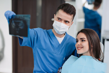 Fototapeta na wymiar Dentist and female patient looking to x-ray