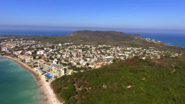 A beautiful aerial drone video of Punta De Mita Nayarit Mexico showing the green jungle and turquoise seas with ocean waves rolling into the sandy beaches near the town of Punta Mita Mexico