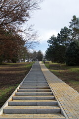 Fototapeta na wymiar Long staircase leading up the hill in the city park
