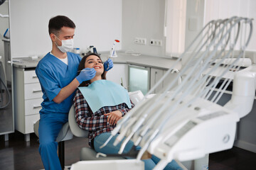 Dentist treats teeth of patient in dental clinic