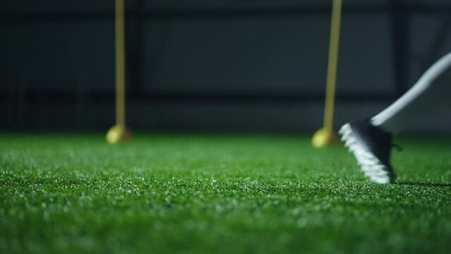 kicking football ball, closeup slow motion, player leg hitting ball on soccer pitch, penalty in match