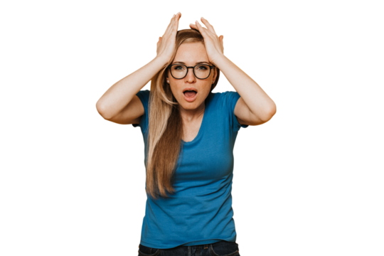Young red haired woman in glasses, blue t-shirt and jeans, with open mouth, holding her head because of headache and many problem, upset against transparent background. Mistake, failure.