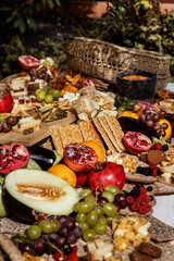 Macedonia de fruta con melón, granada, naranjas, uvas, pan y quesos en brunch.