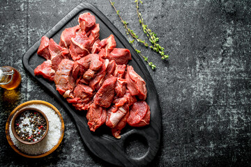 Cut raw beef on a cutting Board with seasonings and oil in a bottle.