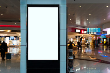 an advertising banner in a shopping center on a blurry background. Blank mock up of vertical street...
