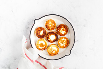Cottage cheese pancakes, cheesecakes, ricotta fritters in a frying pan with fresh strawberries. Healthy and delicious breakfast for Valentine's Day. Top view, a place to copy.