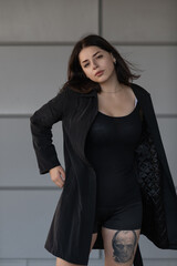 Dramatic close-up portrait of a dark-haired beautiful young girl on a gray background.