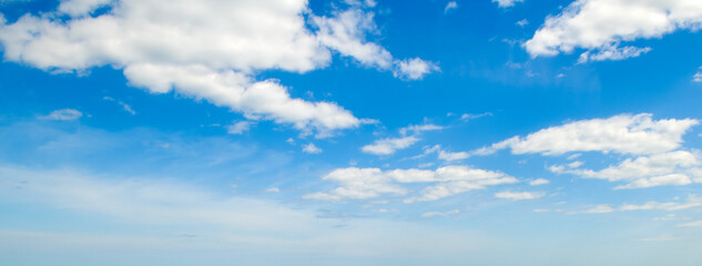 Blue sky and cumulus clouds. Wide photo.