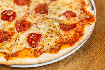 fast food, italian kitchen and eating concept - close up of sliced pizza margherita on plate