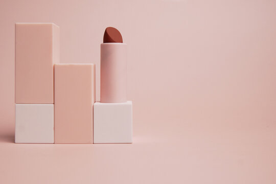 lipstick resting on each other on a pink background