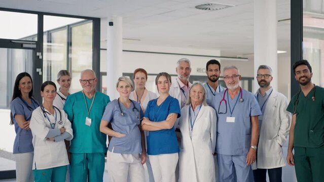 Happy doctors, nurses and other medical staff posing in hospital.