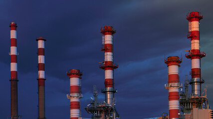 Oil refinery chimneys by night