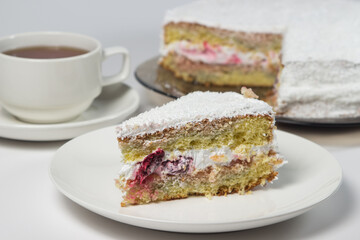 Fototapeta na wymiar Homemade cake with a cup of tea on a white background. Slice of homemade white cake