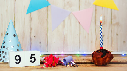 Festive Happy birthday background with number or digit  95. Postcard with a muffin and burning candles. Festive copy space background.