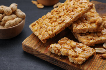 Delicious peanut bars (kozinaki) and ingredients on black table, closeup