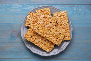 Delicious peanut bars (kozinaki) on light blue wooden table, top view