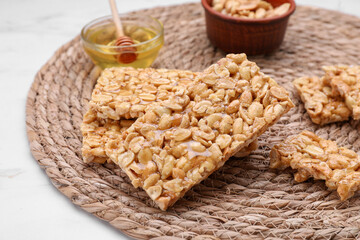 Delicious peanut bars (kozinaki) and ingredients on white marble table