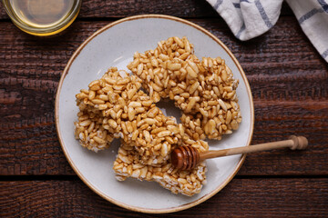 Plate with puffed rice bars (kozinaki) on wooden table, flat lay