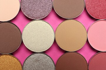 Beautiful eye shadow refill pans on pink background, flat lay