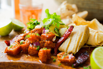 A tamale, in Spanish tamal, is a traditional Mesoamerican dish made of masa, a dough made from nixtamalized corn, which is steamed in a banana or corn leaf.