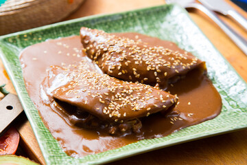 Mexican tacos covered with mole sauce. The term mole refers to various types of highly seasoned Mexican sauces made primarily from chili peppers and spices.