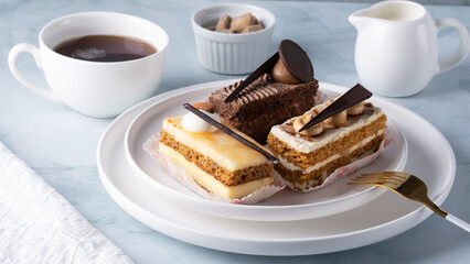 A set of delicious cakes and coffee on a light table