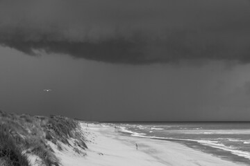 silhouette sur une immense plage vide sous un ciel orageux au bord de la mer du Nord à Oostende en...
