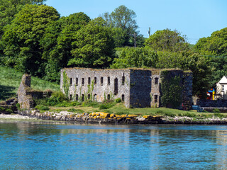 Fototapeta na wymiar The ruins of an ancient stone grain store on the shore of Clonakilty Bay on a sunny spring day. Irish landscape. The ruins of Arundel Grain Store near Clonakilty.