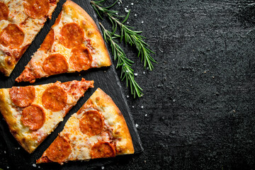 Slices of fragrant pepperoni pizza on a stone Board.