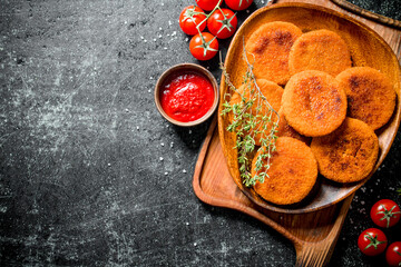 Fish cutlets on a plate with thyme,tomatoes and sauce.