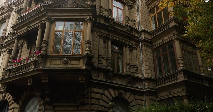 Approaching old 1900s city style building panning to bright october sky. High quality 4k footage