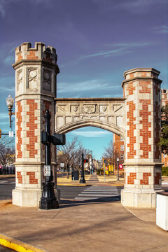 01-02-2022 Norman, USA- Twin arched entrance gates on North Oval of the University of Oklahoma campus to celebrate the University's 100th Anniversary look like castle towers - Town of Norman behind