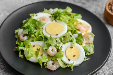 Delicious fresh healthy salad with shrimp, egg, lettuce and flax seeds