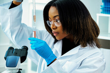 female scientist looking at test tube